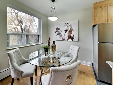 a dining room with a glass table and chairs and a refrigerator