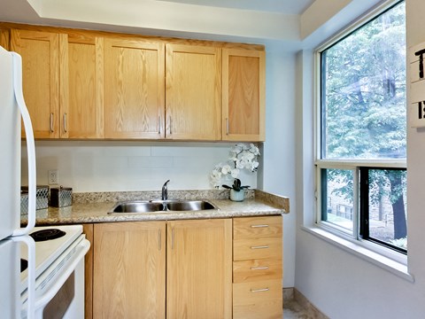 A kitchen with wooden cabinets and a white refrigerator.