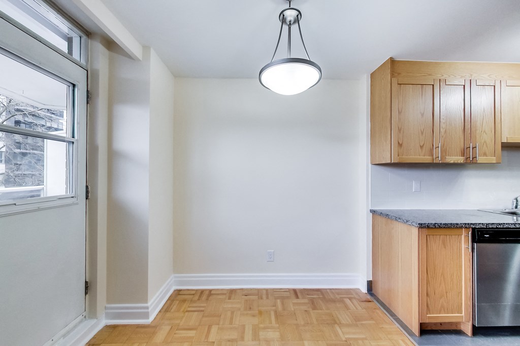 A kitchen with wooden cabinets and a stainless steel dishwasher.