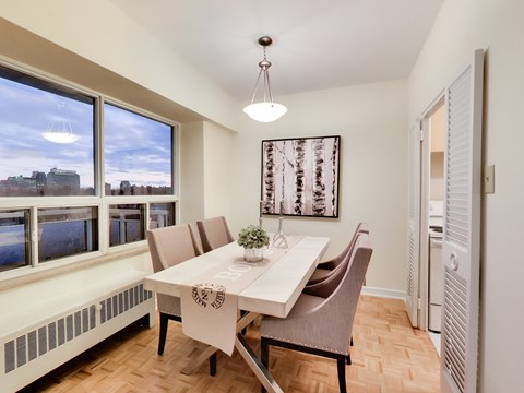 A dining room with a table set for two and a view of the city.