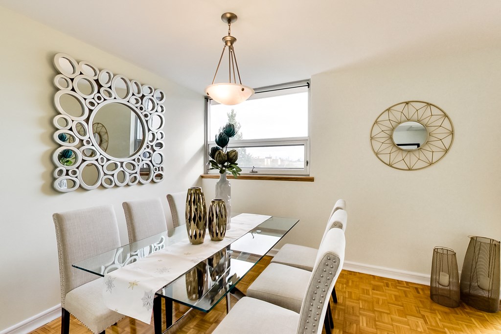 A dining room with a glass table and chairs.