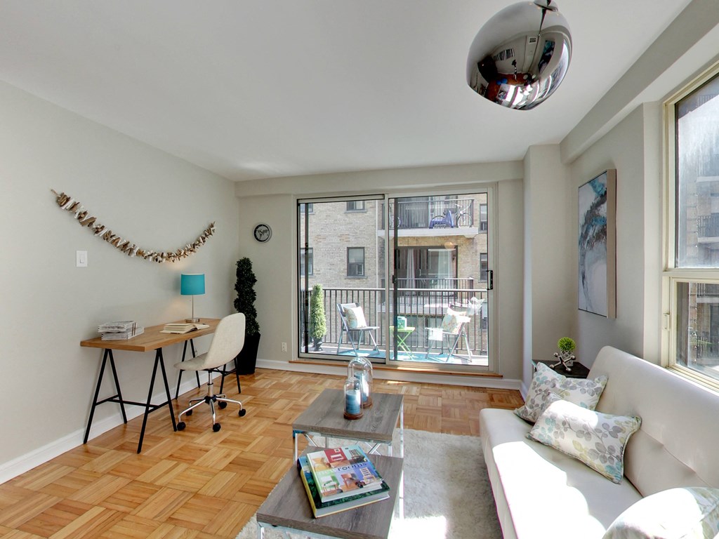 a living room with a couch and a desk and a large window