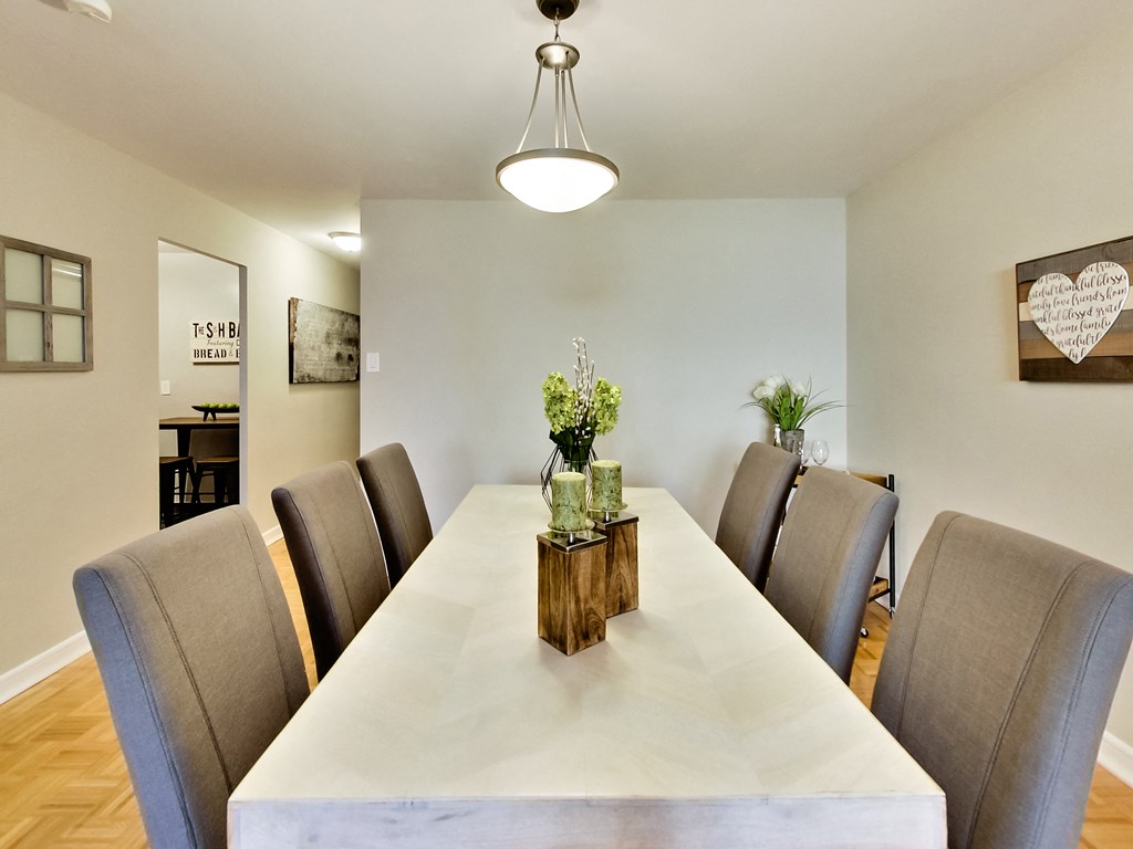 A long table with chairs and a vase of flowers on top.