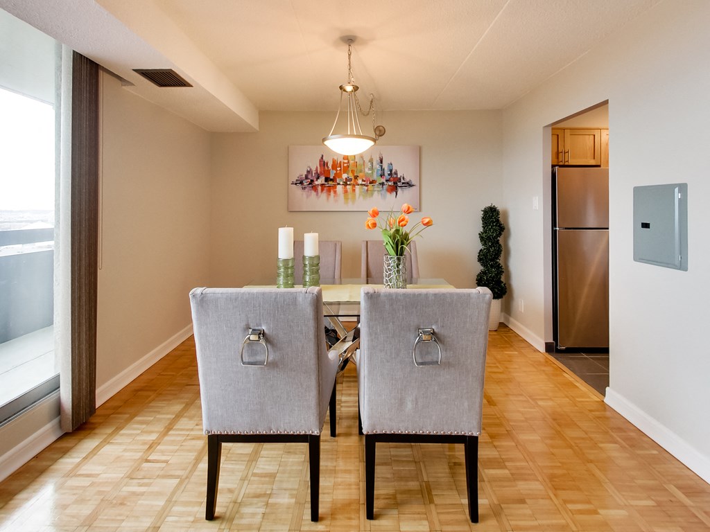 a dining room with a table and chairs and a refrigerator