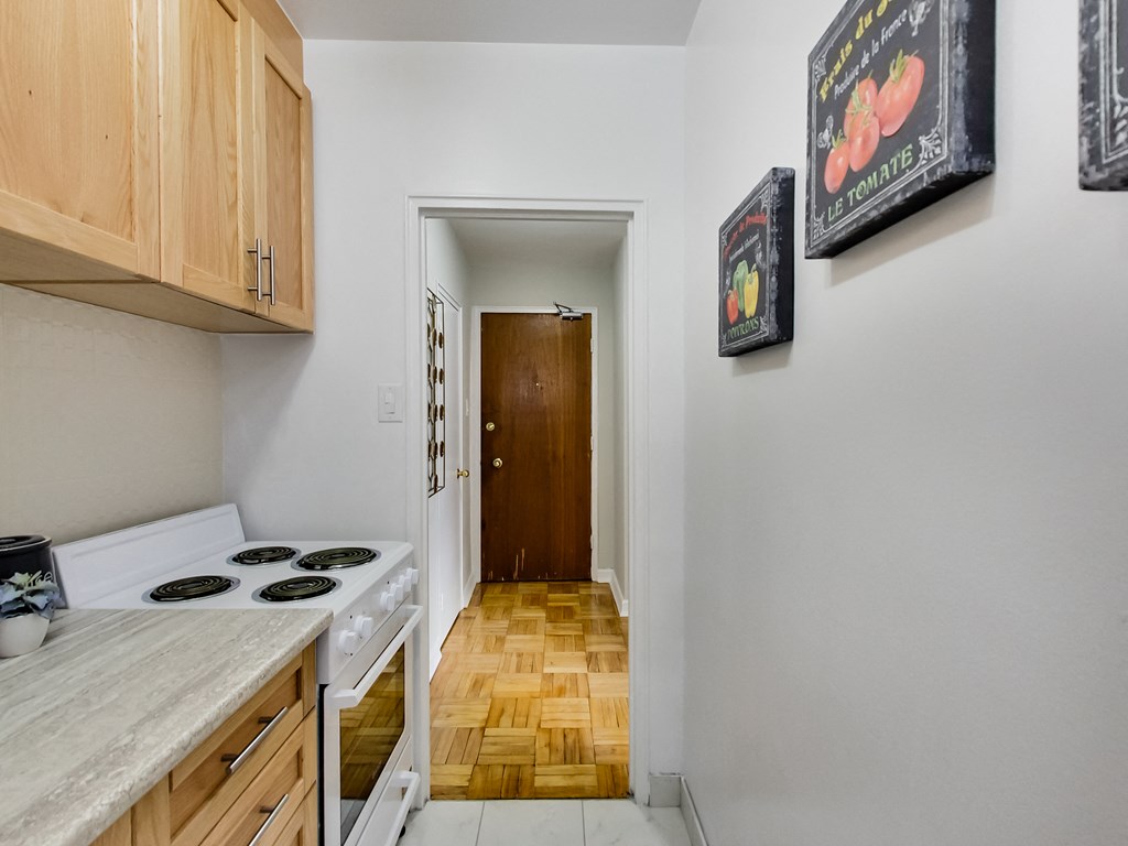 a kitchen with a stove and a door to a hallway