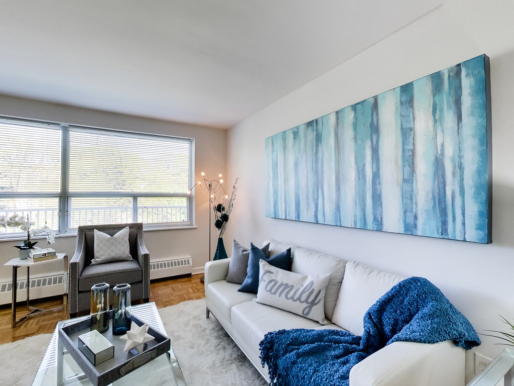 a living room with a white couch and a blue blanket