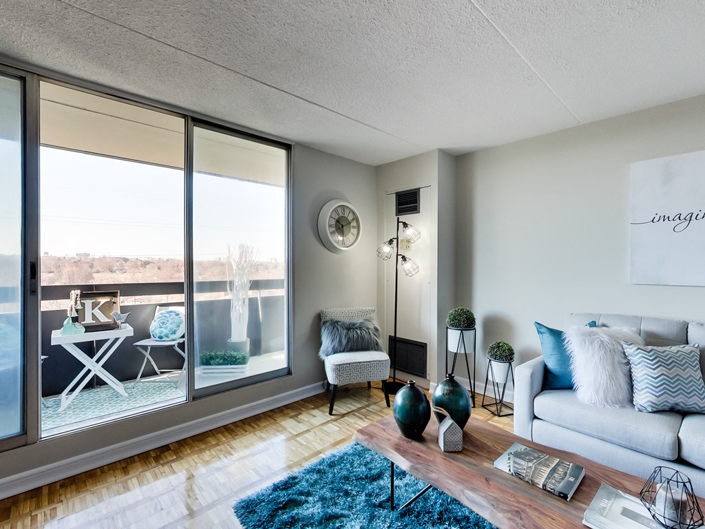 a living room with large windows and a couch and a rug