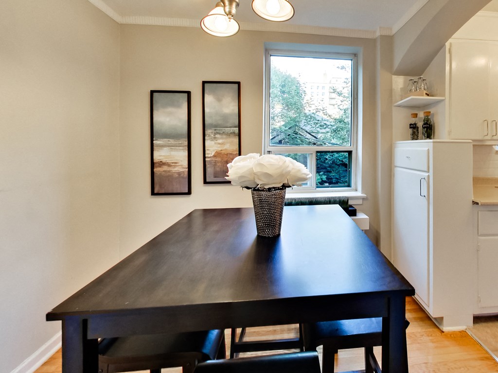 a dining room with a table and chairs and a window