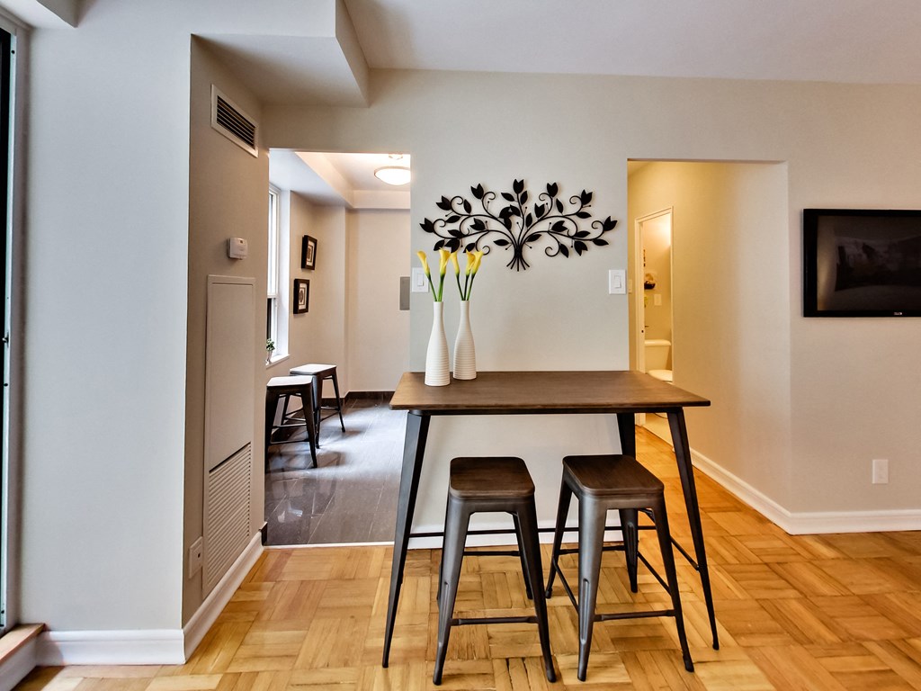 a dining room with a wooden table and three stools