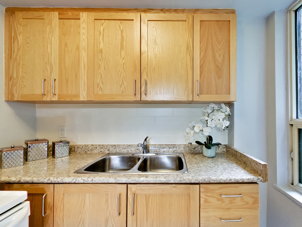 a kitchen with wooden cabinets and granite counter tops and a sink