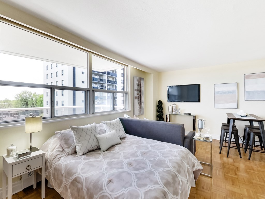 A bedroom with a large bed and a flat screen TV mounted on the wall.
