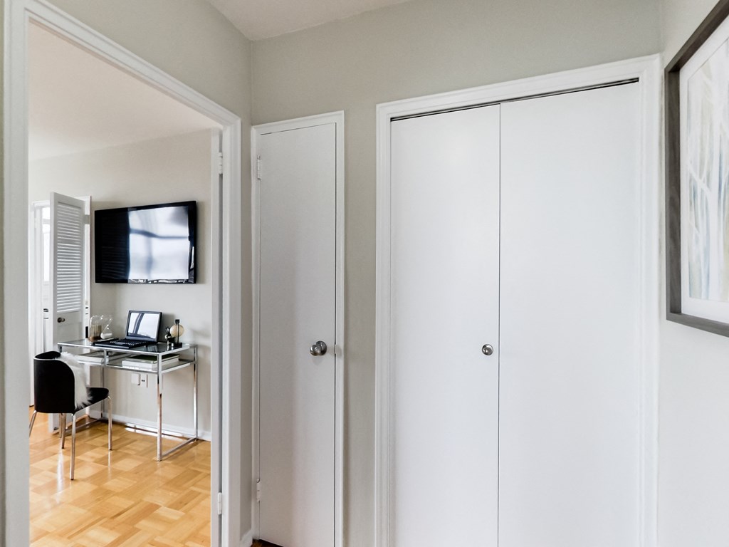 A white door is open to a room with a desk and a chair.