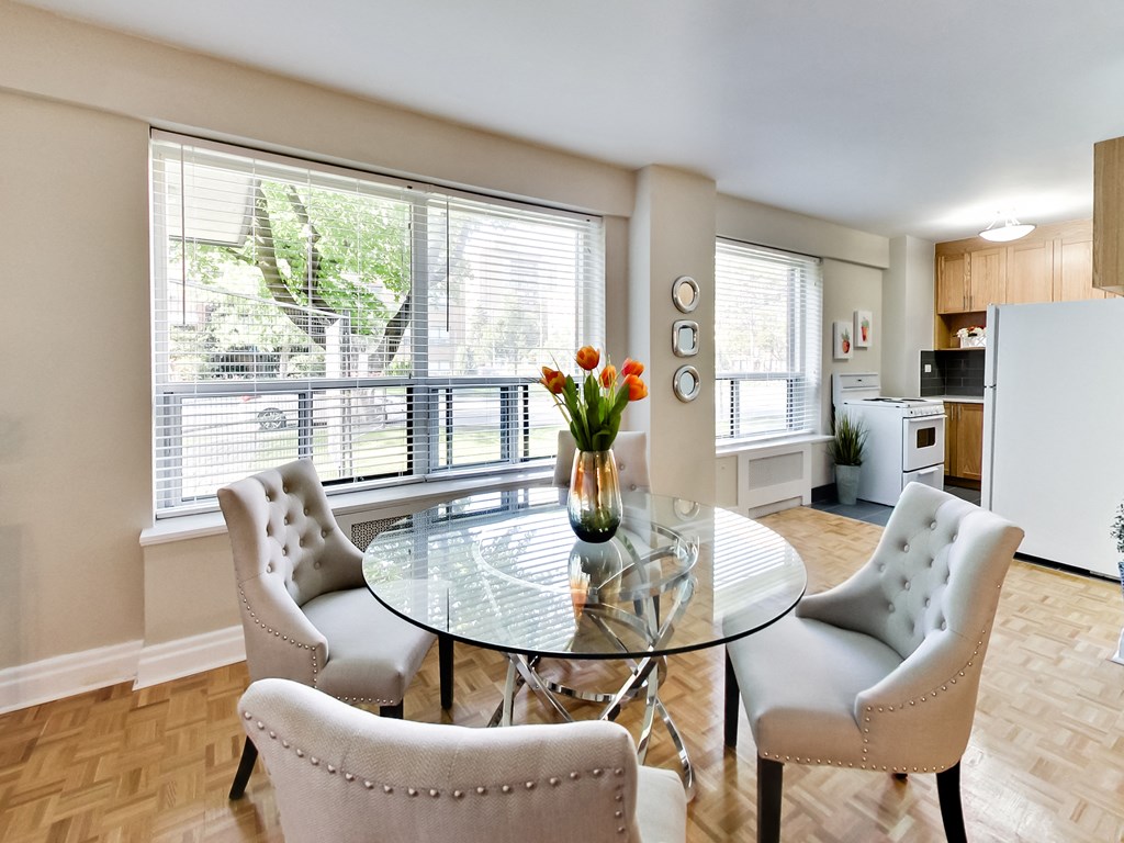 a dining room with a glass table and chairs