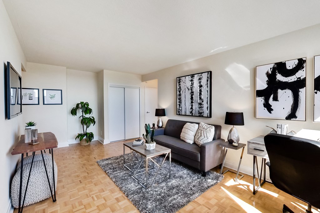 A living room with a couch, a chair, a coffee table, and a TV.
