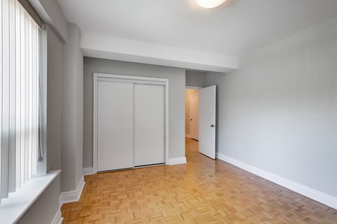 an empty living room with white walls and a wooden floor