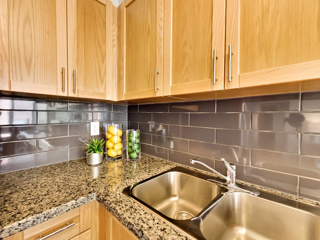 the kitchen has a stainless steel sink and granite counter tops