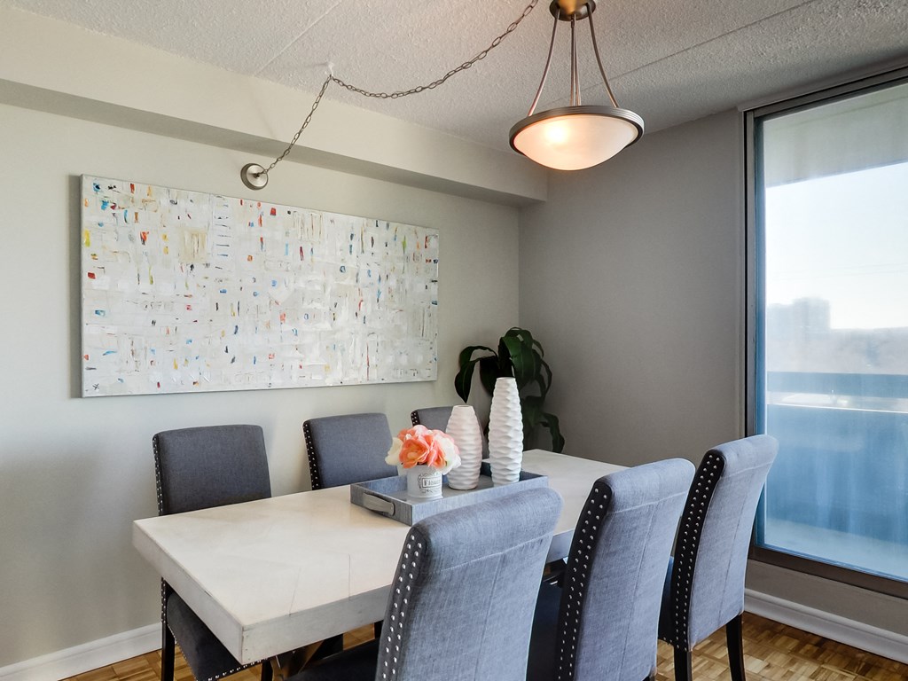 a dining room with a table and chairs and a painting on the wall