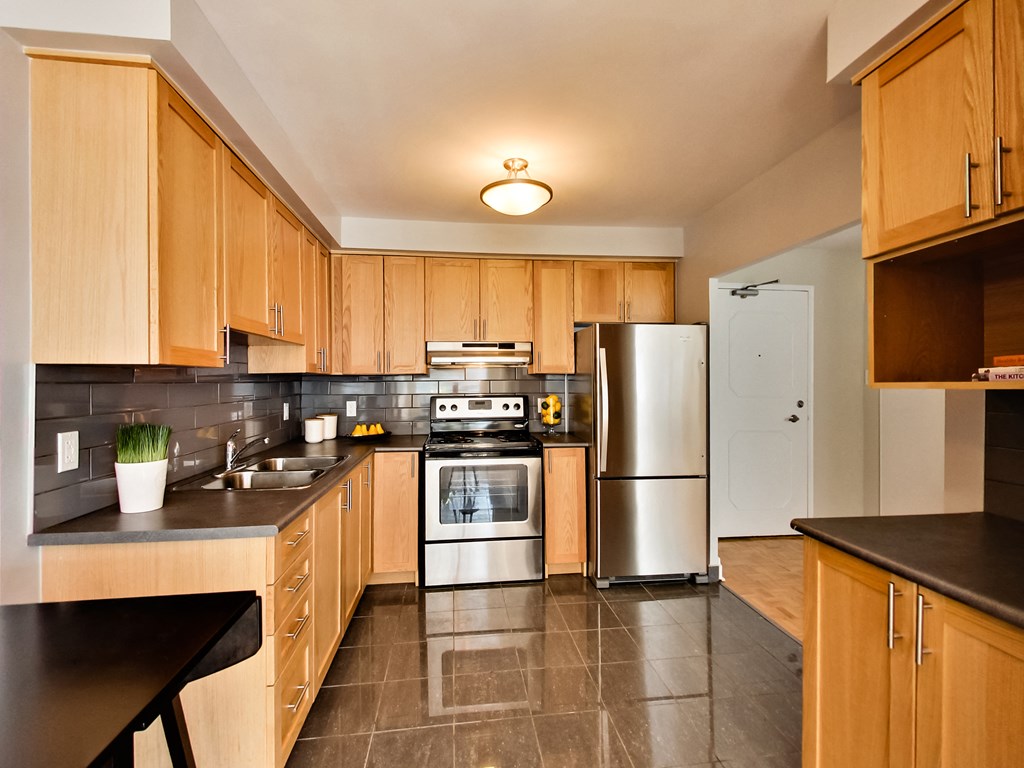 a large kitchen with wooden cabinets and stainless steel appliances