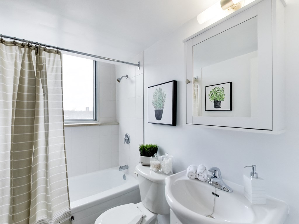 A white bathroom with a tub, toilet, and sink.