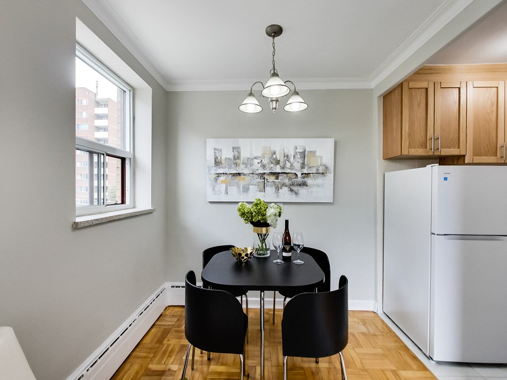 a dining room with a table and chairs and a refrigerator