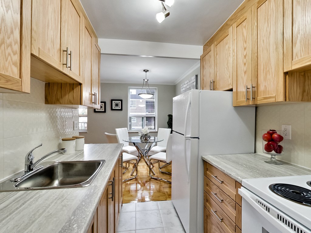 a kitchen with wooden cabinets and a sink and a refrigerator