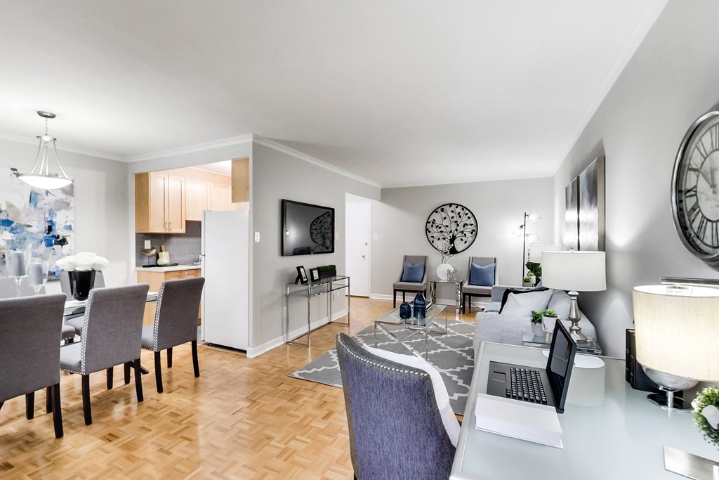 a living room and dining room with a table with a laptop on it
