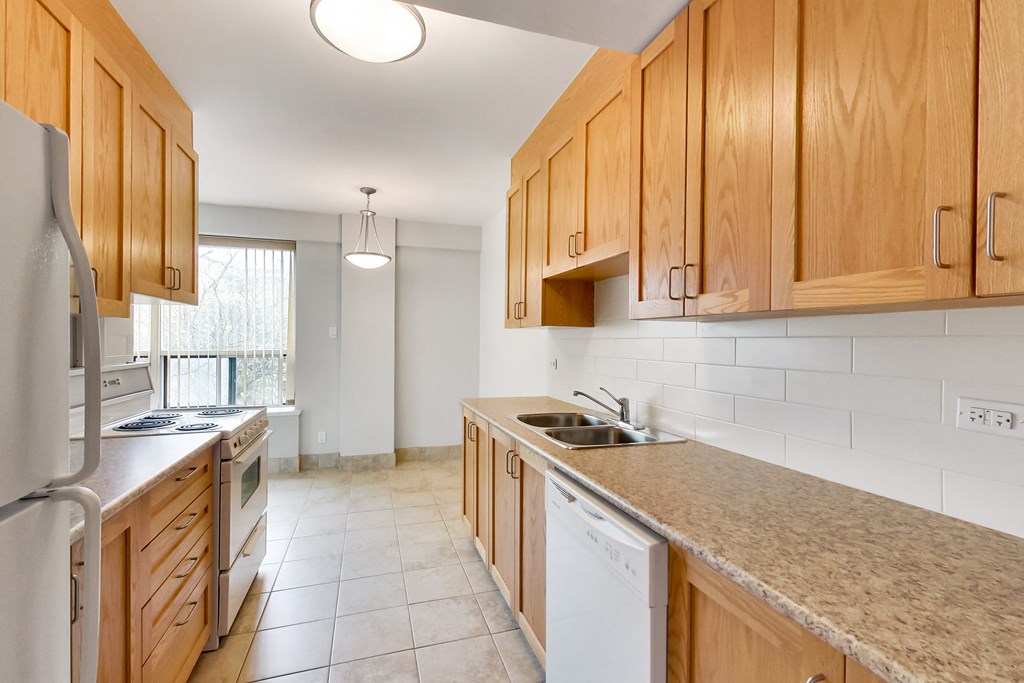 an empty kitchen with wooden cabinets and a counter top