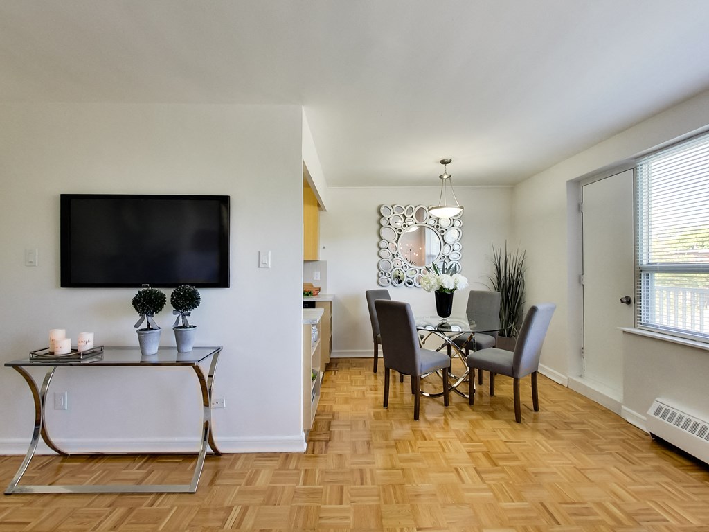 a living room and dining room with a table and chairs and a television