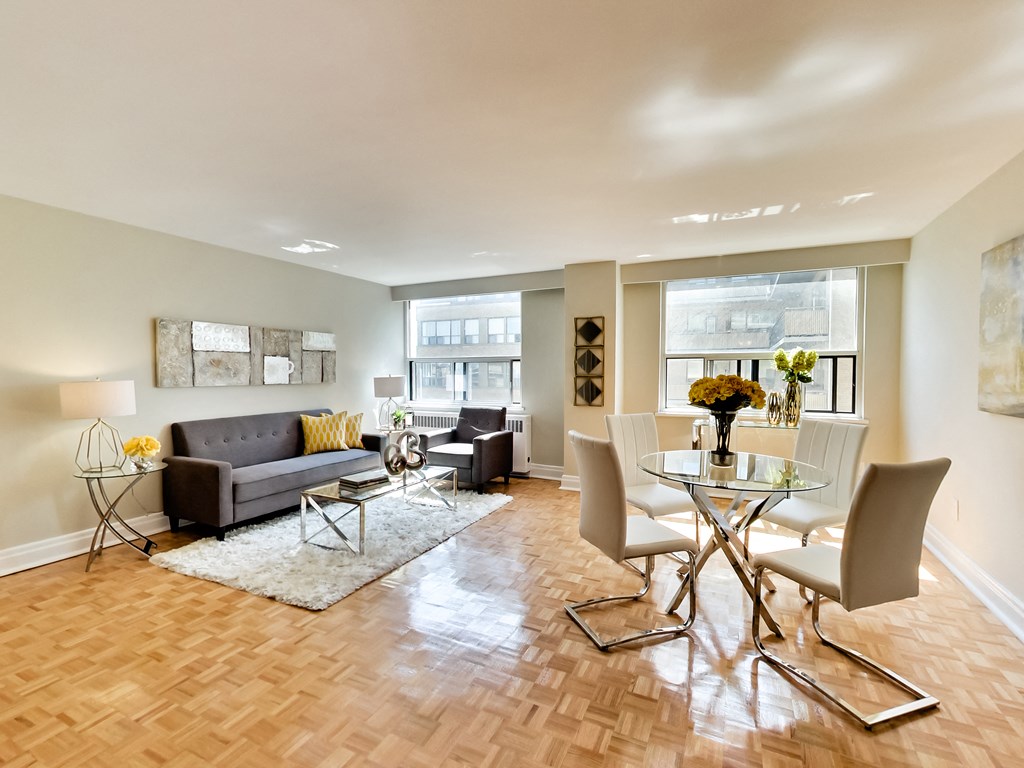 a living room and dining room with a glass table and chairs