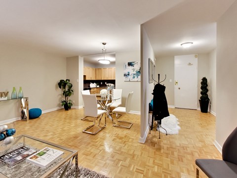 A living room with a glass coffee table and a chair.