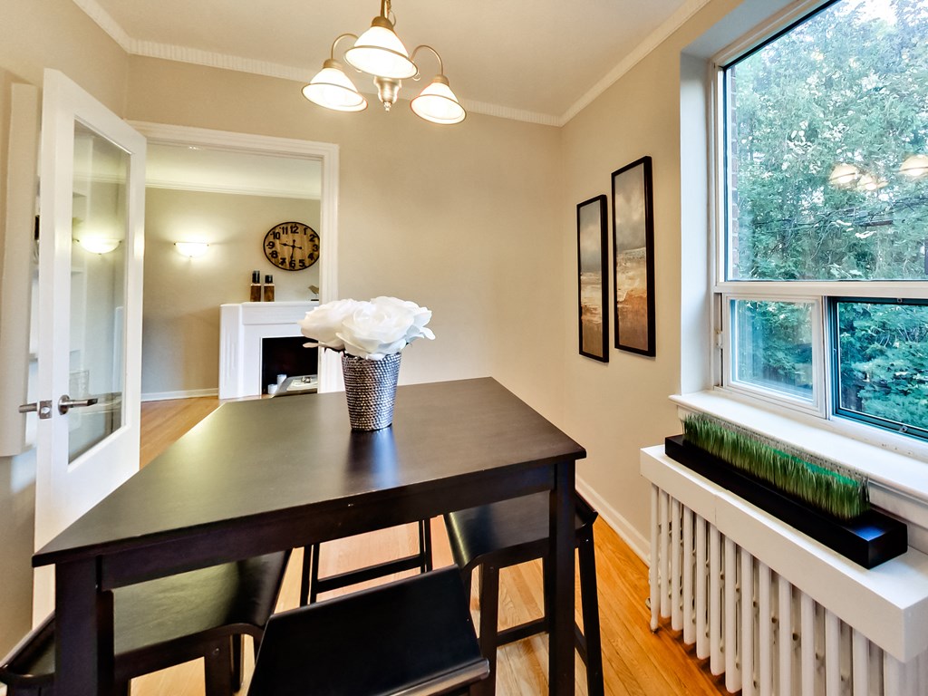 a dining room with a table and chairs and a large window