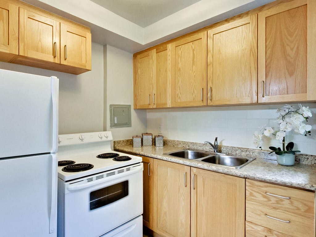 a kitchen with white appliances and wooden cabinets