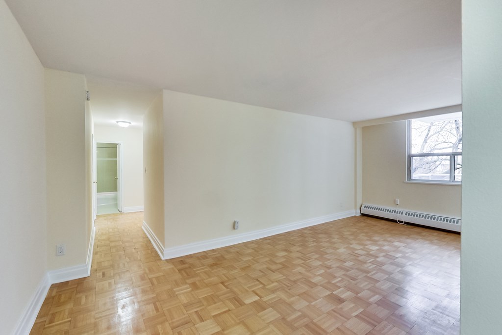A room with wooden flooring and white walls.