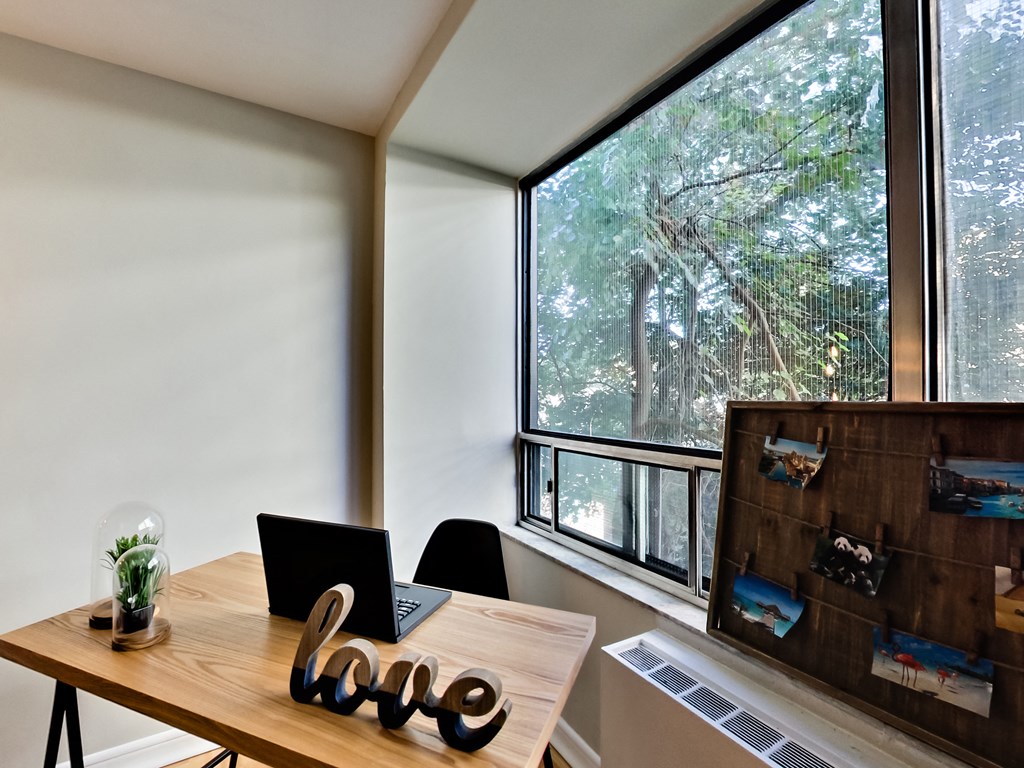 A wooden table with a laptop and a plant on it with a word LOVE on the table.