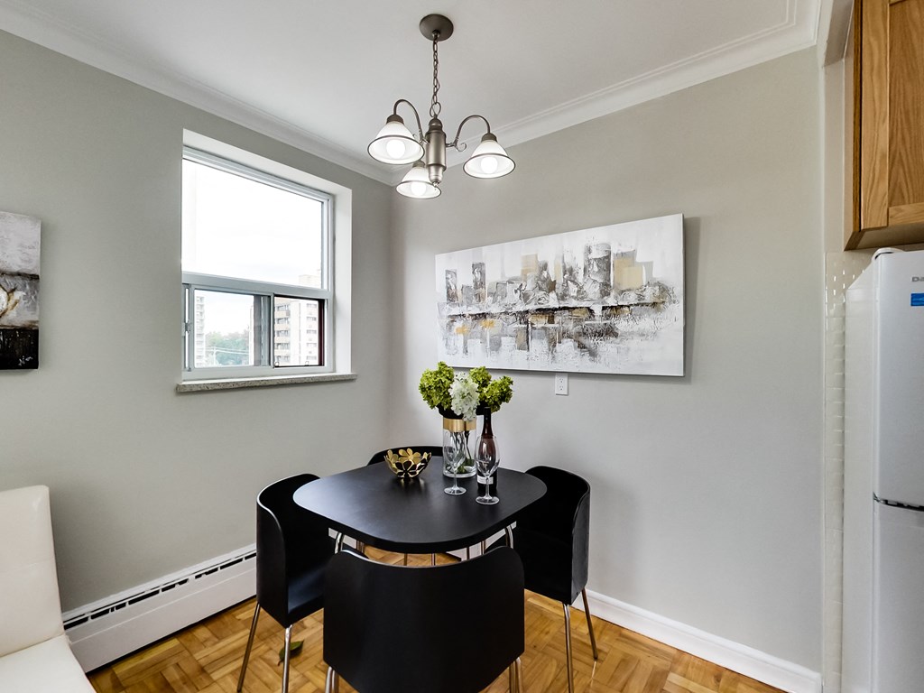 a dining room with a black table and chairs