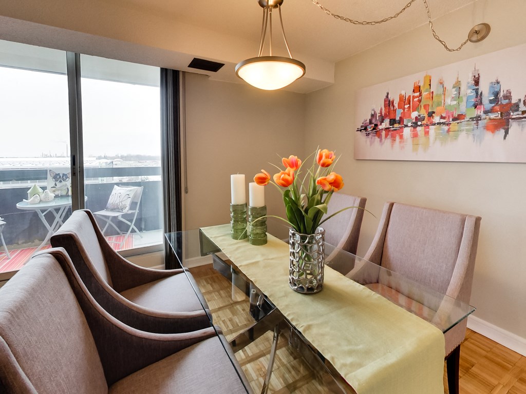 a dining room with a glass table and chairs and a large window