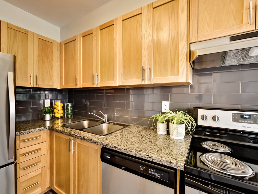 a kitchen with wooden cabinets and granite counter top and black appliances