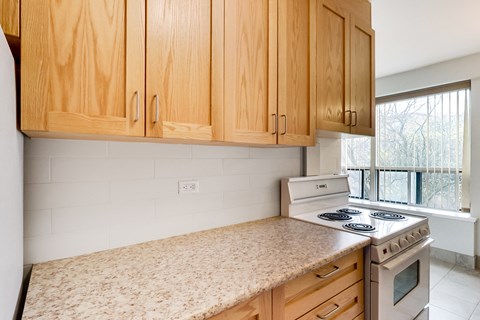 an empty kitchen with wooden cabinets and a stove top oven