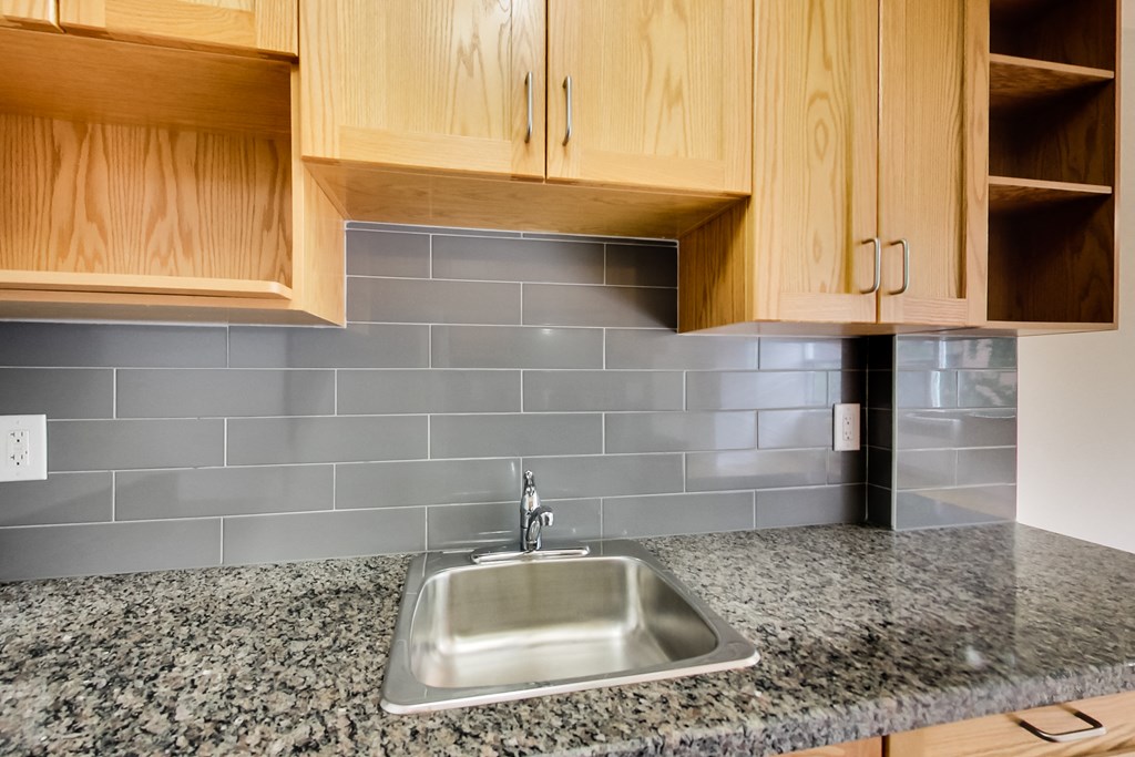 a stainless steel sink in a kitchen with granite counter tops