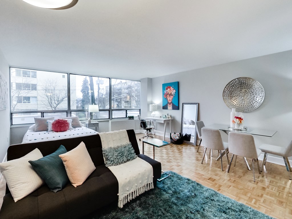 A living room with a couch, chairs, and a dining table.