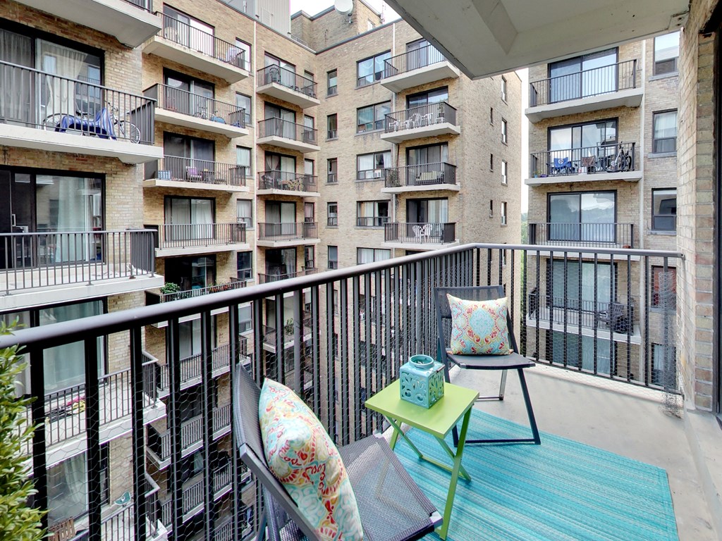a balcony with two chairs and a table on a balcony