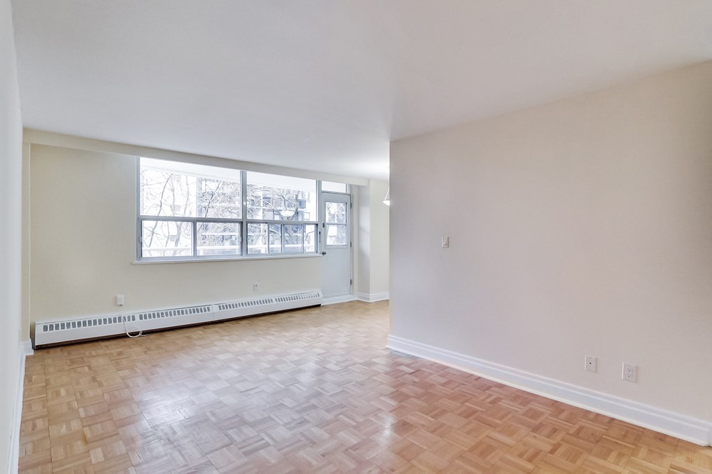 A room with a window and a radiator on the floor.