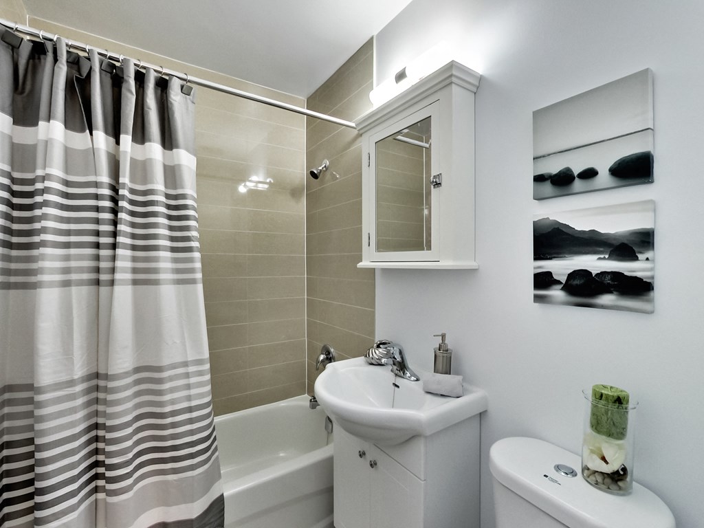 a bathroom with a shower curtain and a sink and a toilet