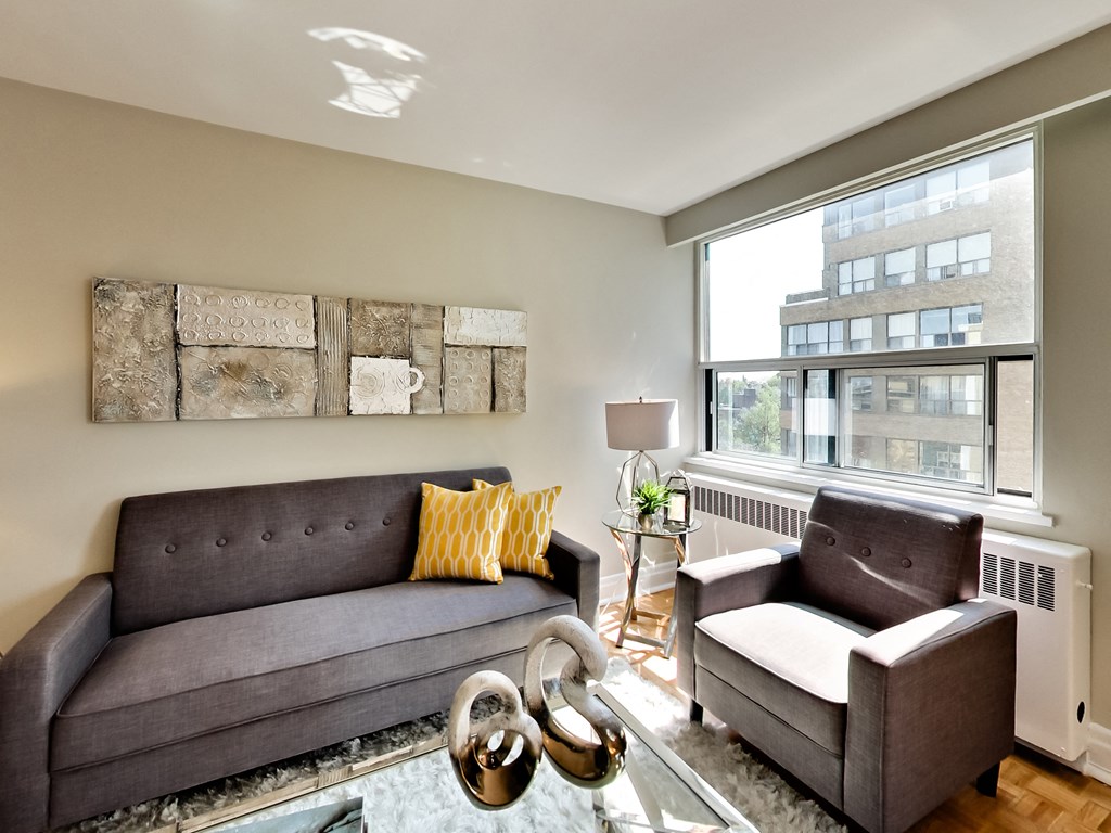 a living room with a couch and chairs and a large window