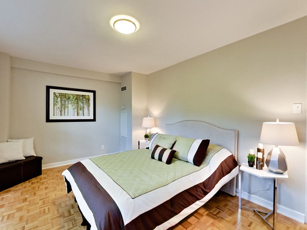 a bedroom with a bed and a table with two lamps