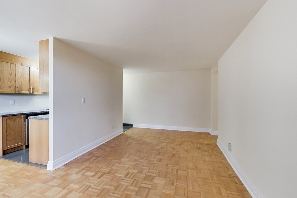 A room with wooden flooring and white walls.
