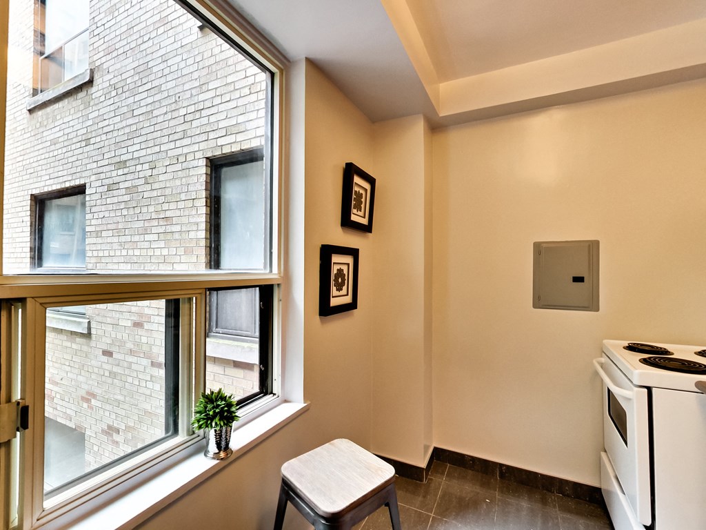 a kitchen with a large window and a stove and a stool