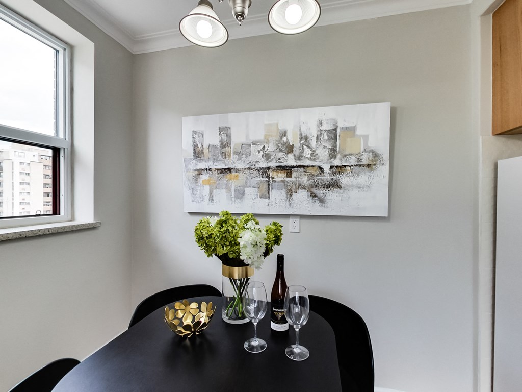 a dining room with a black table and a painting on the wall