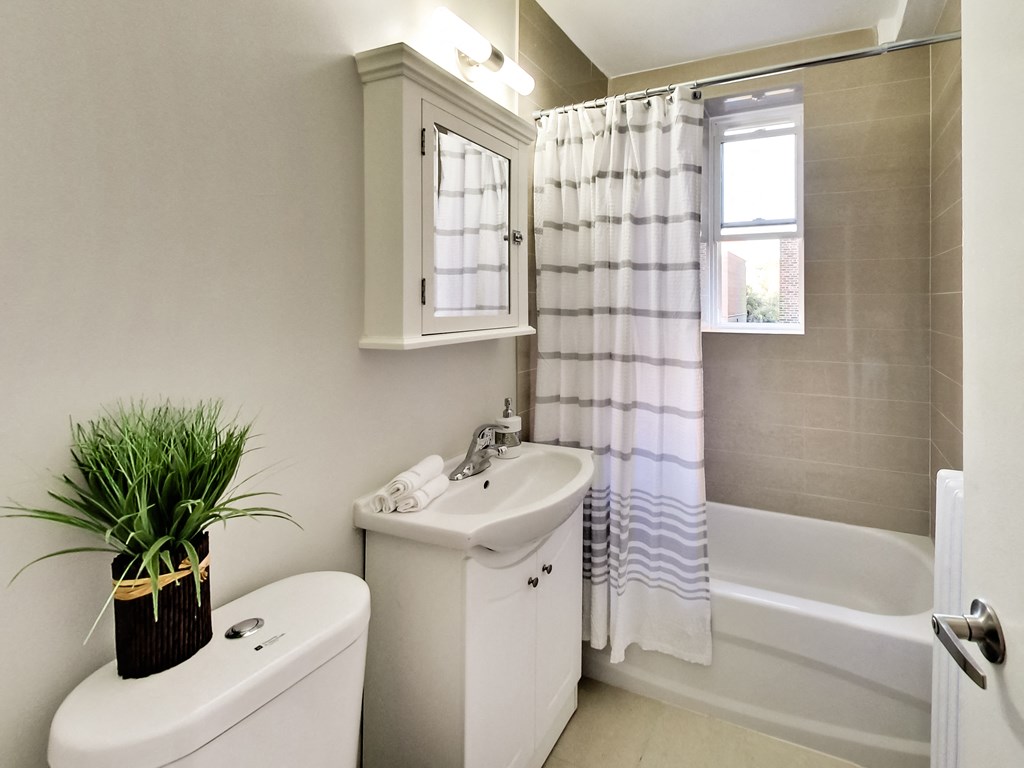 A white bathroom with a toilet, sink, and bathtub.