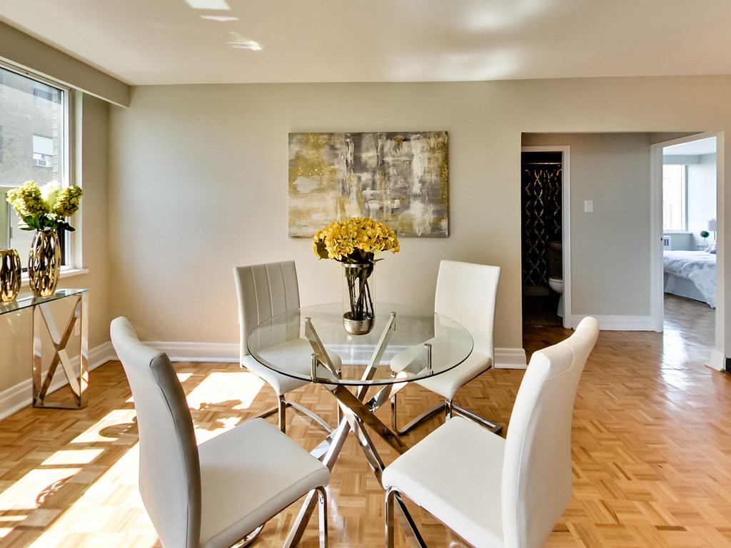 a dining room with a glass table and white chairs